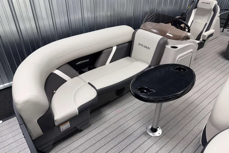 Slide: The Image of 2026 Sylvan Mirage X3 CLZ DH pontoon boat interior with plush seating and table. - 2