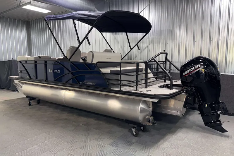 Slide: The Image of 2026 Sylvan Mirage X3 CLZ DH pontoon boat with Mercury outboard in a showroom. - 24