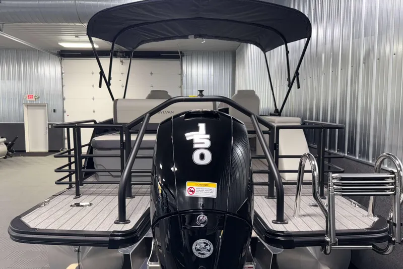 Slide: The Image of 2026 Sylvan Mirage X3 CLZ DH pontoon boat with 150 HP engine in a garage. - 25