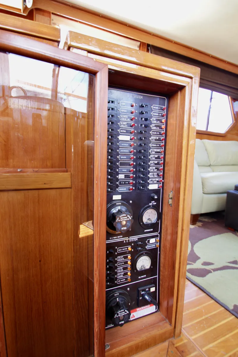 Slide: The Image of Electrical panel inside a 1984 Symbol 51 yacht, featuring wooden cabinetry and modern controls. - 19