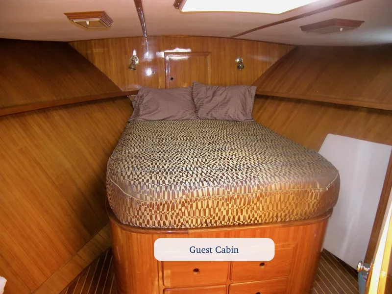 Slide: The Image of Guest cabin with wooden interior and patterned bedding on a 1984 Symbol 51 yacht. - 24