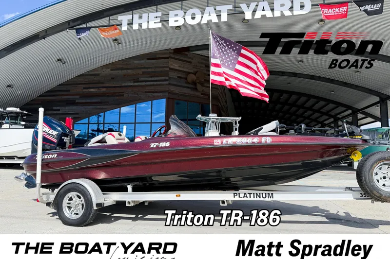 The Image of 2000 Triton TR-186 boat on trailer at The Boat Yard, American flag displayed. - 1