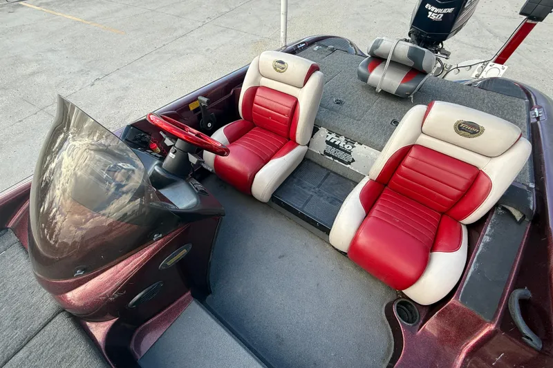 Slide: The Image of 2000 Triton Tr-186 boat interior with red and white seats, steering wheel, and Evinrude motor. - 12