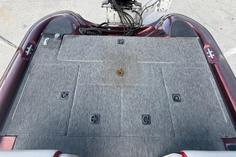 Slide: The Image of 2000 Triton Tr-186 boat deck with carpeted storage compartments and hardware. - 13