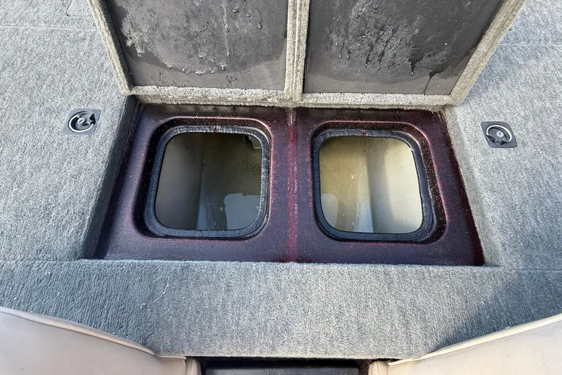 Slide: The Image of 2000 Triton Tr-186 boat storage compartments with open lids, showing interior space. - 14