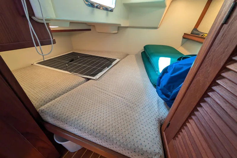 Slide: The Image of Cozy cabin interior of 1999 Island Packet 320 sailboat with bedding and storage. - 11