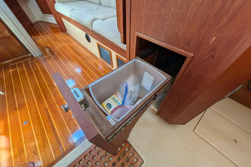 Slide: The Image of Interior of 1999 Island Packet 320 sailboat with open storage compartment. - 14