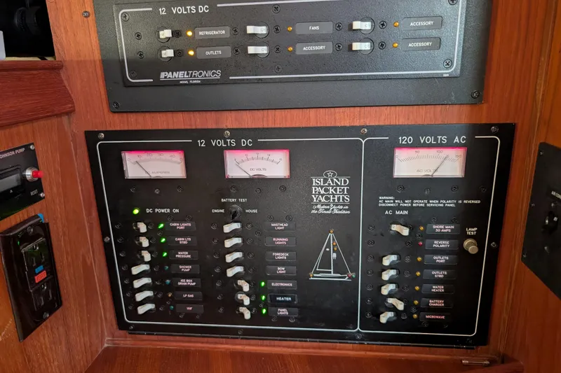 Slide: The Image of Electrical control panel on a 1999 Island Packet 320 yacht, featuring DC and AC voltage meters. - 15