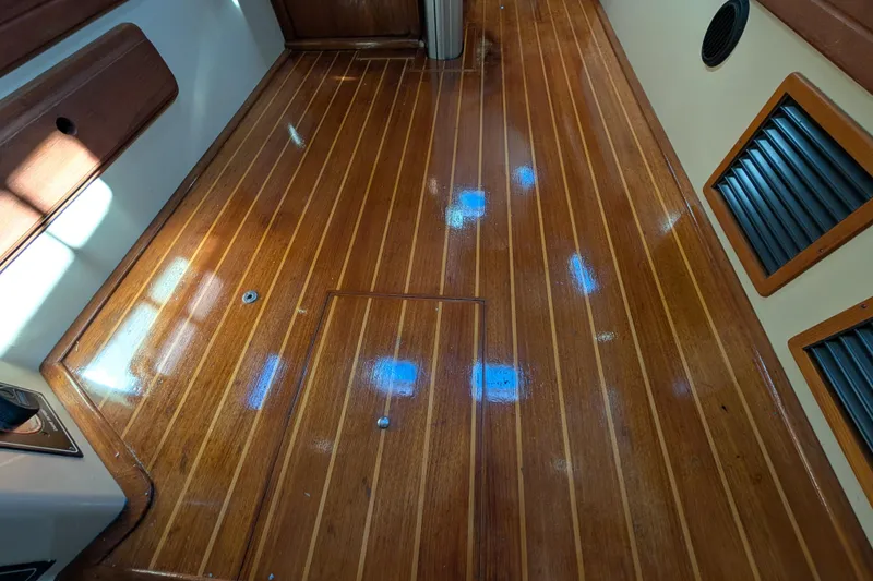 Slide: The Image of Polished wooden floor of a 1999 Island Packet 320 sailboat interior. - 19