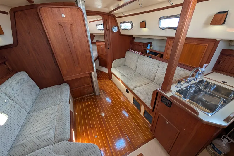 Slide: The Image of Interior of 1999 Island Packet 320 sailboat with wood finish and cozy seating area. - 2