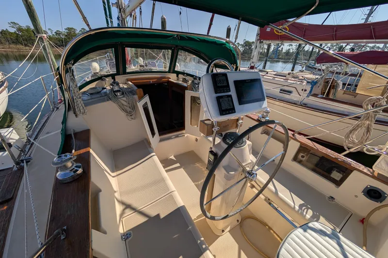 Slide: The Image of 1999 Island Packet 320 sailboat cockpit with steering wheel and navigation instruments. - 20