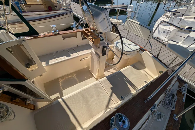 Slide: The Image of 1999 Island Packet 320 sailboat cockpit with steering wheel and seating. - 22