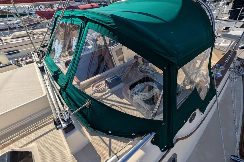 Slide: The Image of 1999 Island Packet 320 sailboat with green canvas cover at marina. - 29