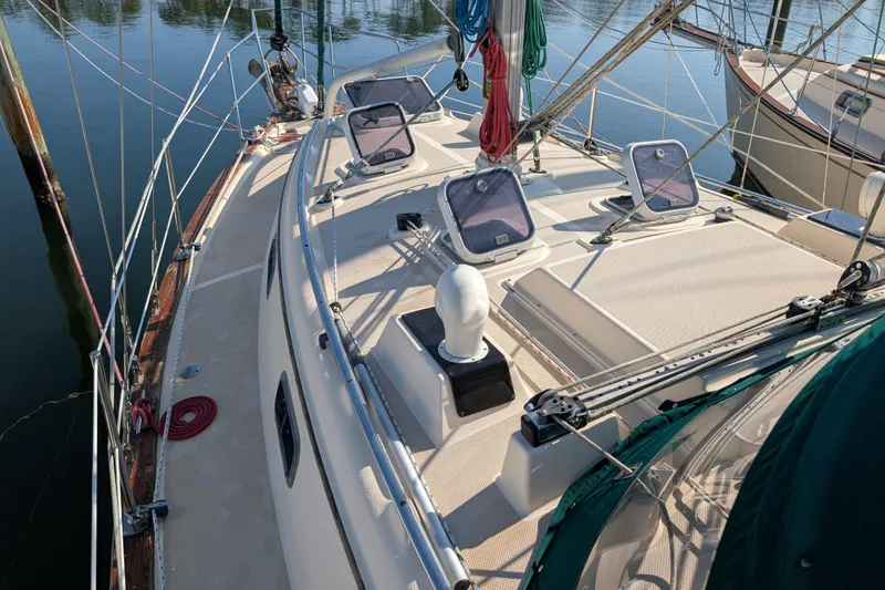 Slide: The Image of 1999 Island Packet 320 sailboat deck with hatches and rigging in a marina. - 30