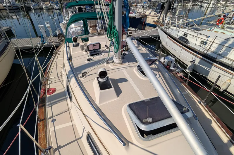Slide: The Image of 1999 Island Packet 320 sailboat deck view in marina, showcasing rigging and hatches. - 33
