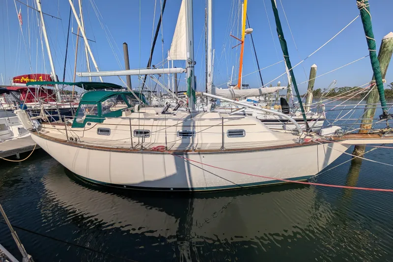 Slide: The Image of 1999 Island Packet 320 sailboat docked at a marina under clear blue skies. - 39