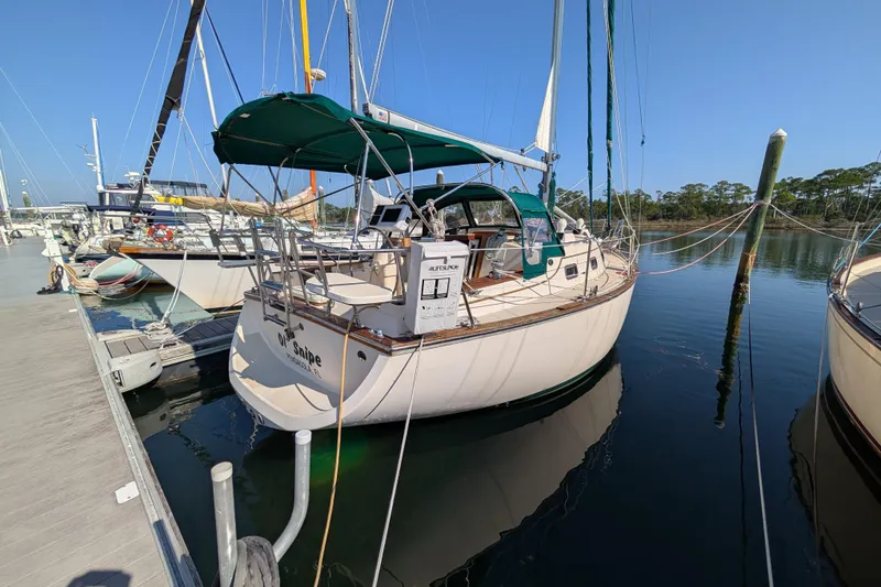 Slide: The Image of 1999 Island Packet 320 sailboat docked at marina under clear blue sky. - 41