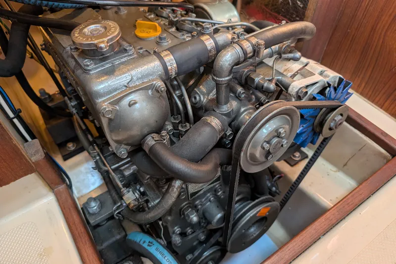 Slide: The Image of Engine of a 1999 Island Packet 320 sailboat, showcasing mechanical components and belts. - 42