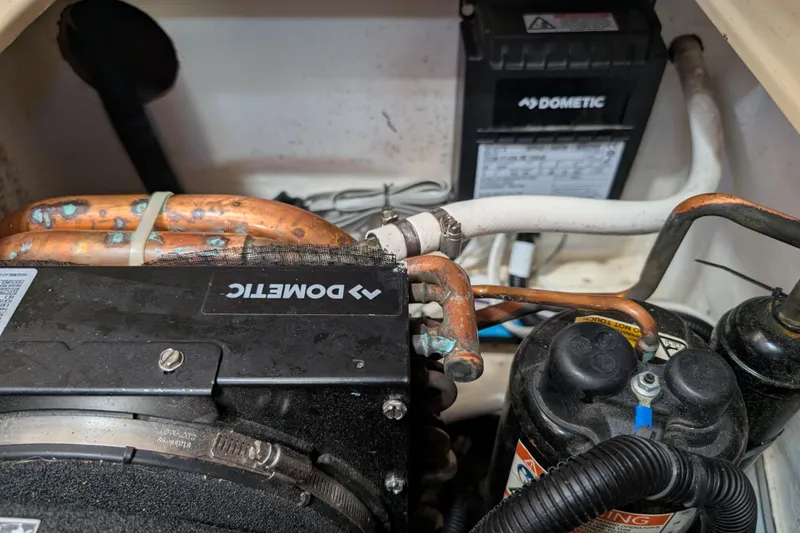 Slide: The Image of Engine compartment of a 1999 Island Packet 320 with Dometic components and copper piping. - 49