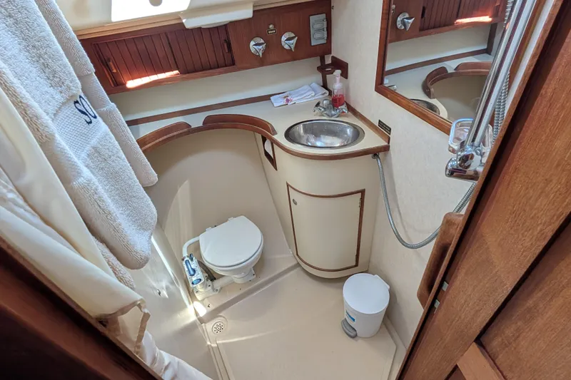 Slide: The Image of Bathroom interior of 1999 Island Packet 320 sailboat, featuring sink, toilet, and shower. - 7