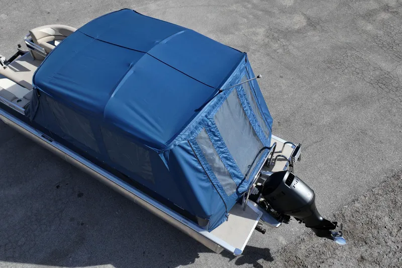 Slide: The Image of 2026 Avalon Venture 85 Rear Fish boat with blue canopy and outboard motor. - 4