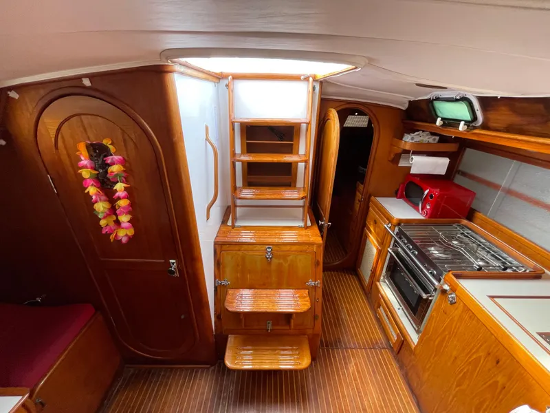 Slide: The Image of Interior of 1980 Davidson 44 sailboat with wooden finish and vibrant decor. - 15