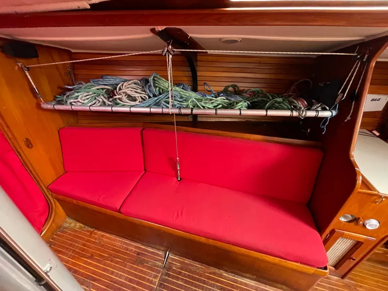 Slide: The Image of Red-cushioned seating area in 1980 Davidson 44 yacht interior with rope storage above. - 10