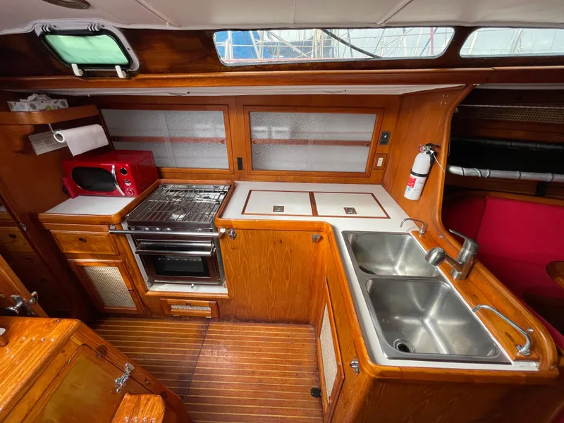 Slide: The Image of 1980 Davidson 44 yacht kitchen with wood cabinetry, dual sinks, stove, and microwave. - 12