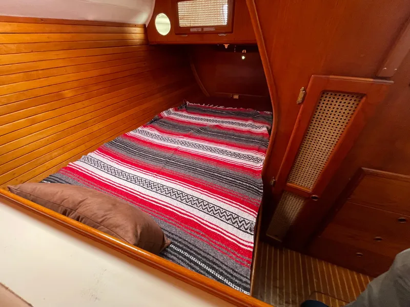 Slide: The Image of Cozy cabin interior of 1980 Davidson 44 sailboat with striped bedding and wooden paneling. - 17