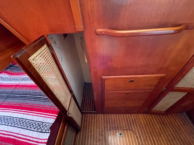 Slide: The Image of Interior of 1980 Davidson 44 boat with wooden cabinets and striped fabric. - 18