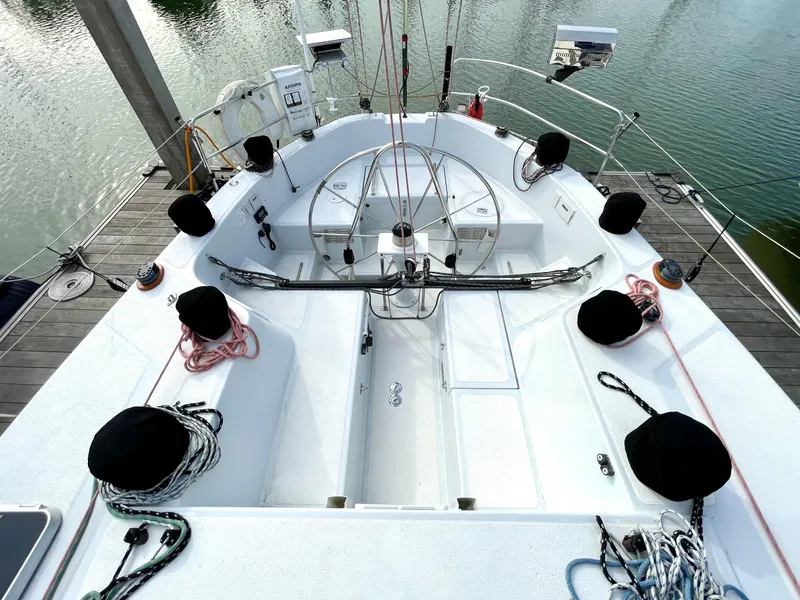 Slide: The Image of Cockpit of 1980 Davidson 44 sailboat with ropes and winches, docked by calm water. - 6