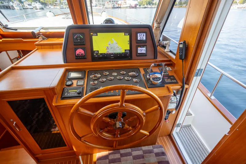 Slide: The Image of Helm of 2006 Grand Banks 47 Europa yacht with navigation equipment and wooden steering wheel. - 19