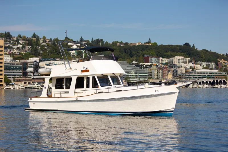 Slide: The Image of 2006 Grand Banks 47 Europa yacht cruising on a calm urban waterfront. - 2