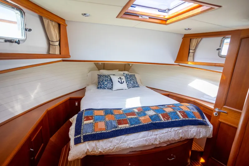 Slide: The Image of Luxurious 2006 Grand Banks 47 Europa yacht cabin with cozy bed and nautical decor. - 21