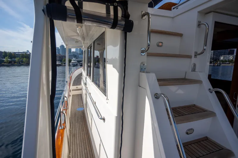 Slide: The Image of 2006 Grand Banks 47 Europa yacht deck with wooden steps and waterfront view. - 34