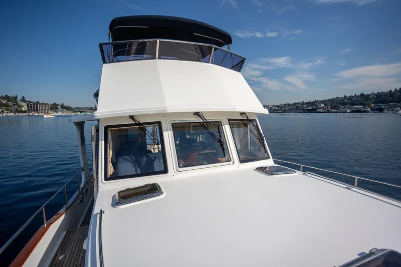Slide: The Image of 2006 Grand Banks 47 Europa yacht on calm water under clear blue sky. - 35