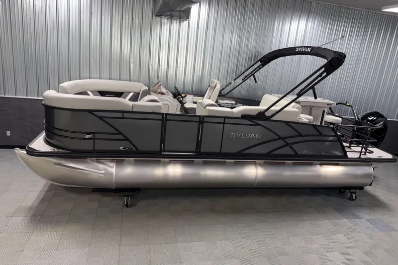 Slide: The Image of 2026 Sylvan MIRAGE X3 DLZ BAR pontoon boat in a showroom with sleek design. - 0