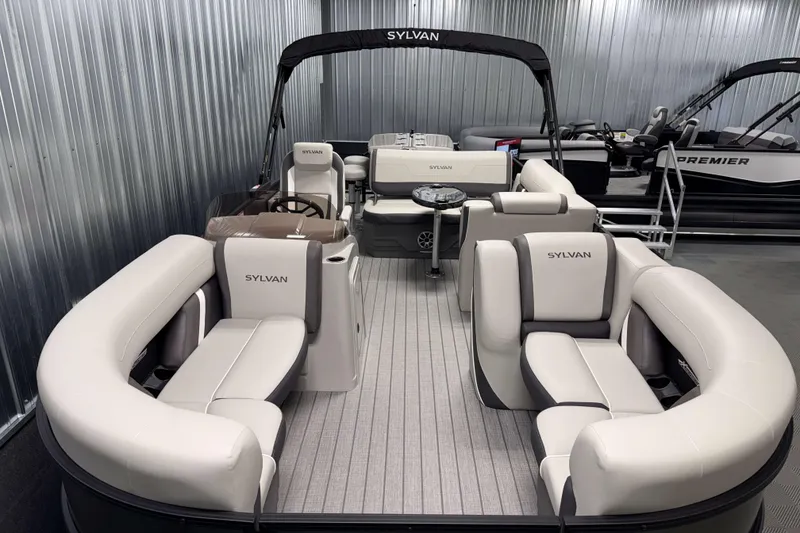 Slide: The Image of 2026 Sylvan MIRAGE X3 DLZ BAR pontoon boat with luxurious seating in a showroom. - 1