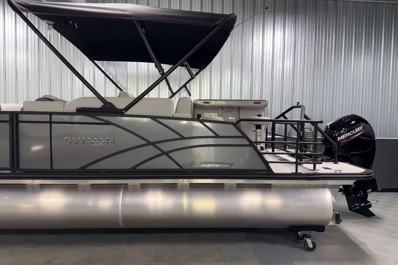 Slide: The Image of 2026 Sylvan MIRAGE X3 DLZ BAR pontoon boat with Mercury outboard motor in showroom. - 24