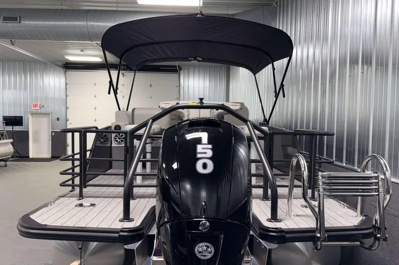 Slide: The Image of 2026 Sylvan MIRAGE X3 DLZ BAR pontoon boat with powerful engine in a modern showroom. - 26