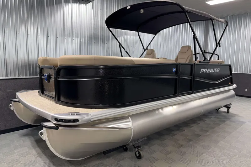 Slide: The Image of 2026 Premier 200 Sunscape RL pontoon boat in showroom, featuring sleek black design and canopy. - 2