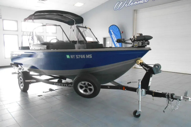 Slide: The Image of 2021 Crestliner 1650 Fish Hawk WT JS boat on trailer in showroom. - 2
