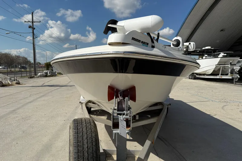 Slide: The Image of 2018 NauticStar boat on trailer with Minn Kota motor, parked outdoors. - 2