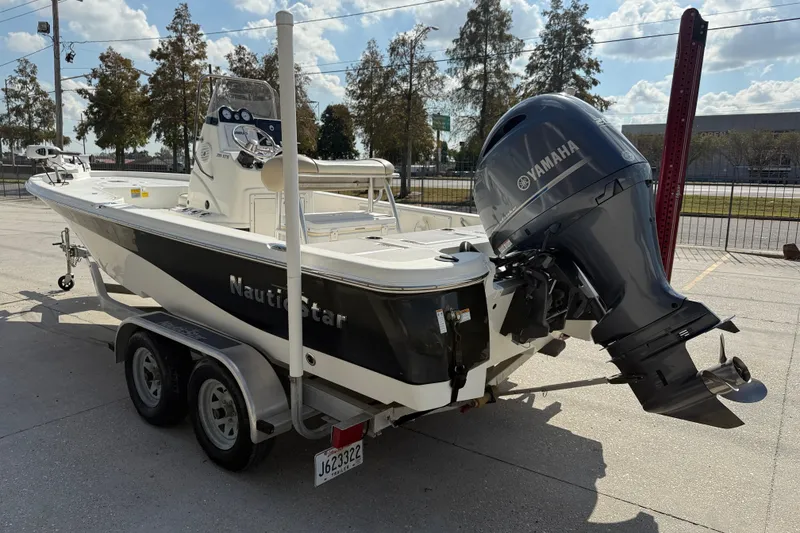 Slide: The Image of 2018 NauticStar boat with Yamaha outboard motor on a trailer, parked outdoors. - 4
