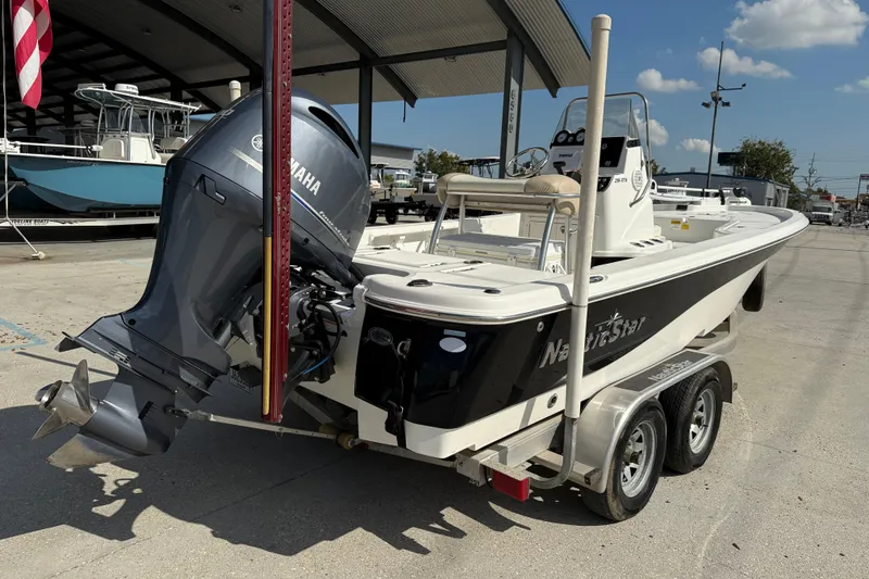 Slide: The Image of 2018 NauticStar boat on trailer with Yamaha outboard motor, parked outdoors. - 6