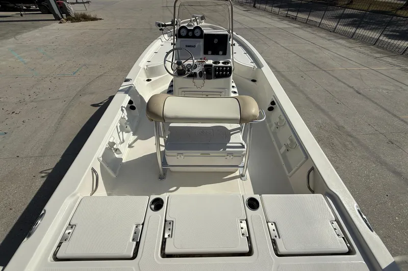 Slide: The Image of 2018 NauticStar boat interior with steering console and seating, docked on concrete. - 7