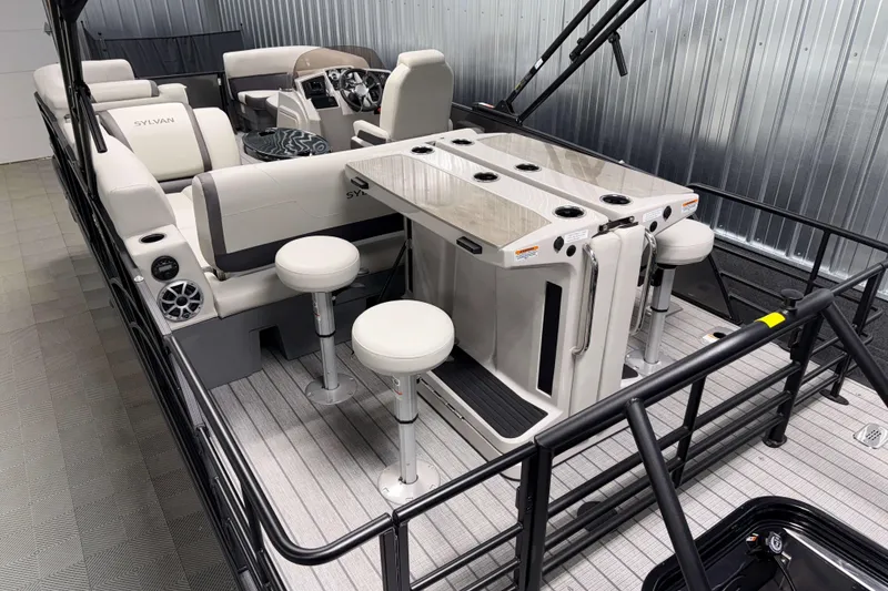 Slide: The Image of 2026 Sylvan MIRAGE X3 DLZ BAR pontoon boat interior with bar stools and seating. - 18