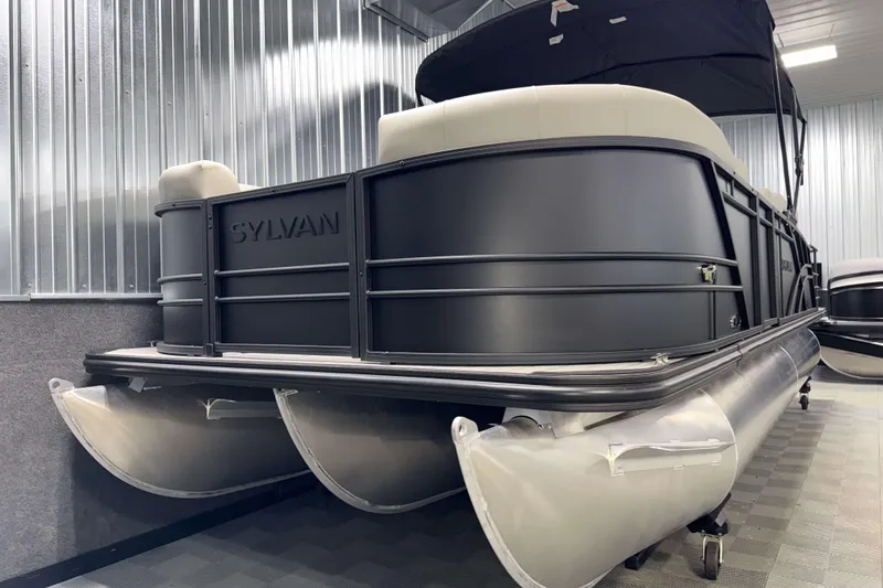 Slide: The Image of 2026 Sylvan MIRAGE X3 DLZ BAR pontoon boat in a showroom, showcasing sleek design. - 23
