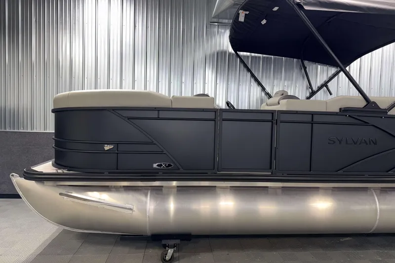 Slide: The Image of 2026 Sylvan MIRAGE X3 DLZ BAR pontoon boat with sleek black design and canopy. - 24