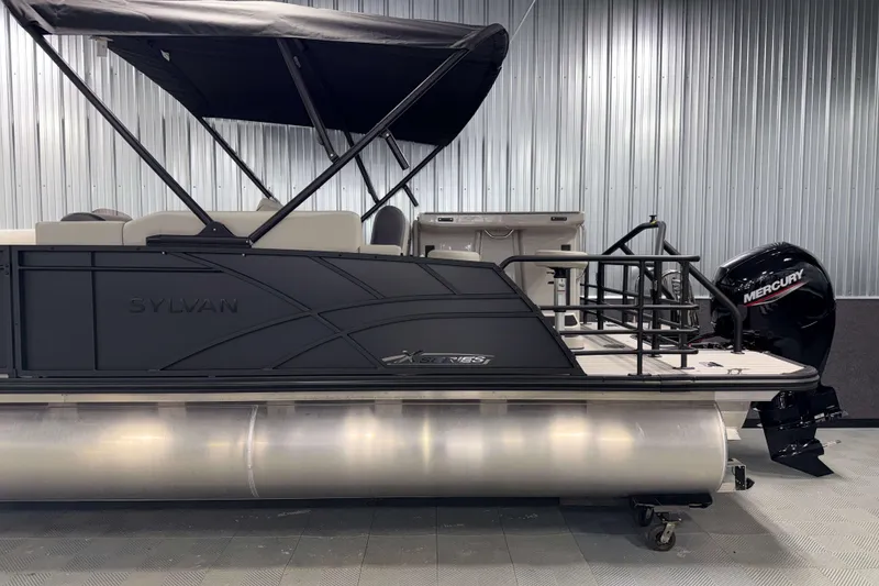 Slide: The Image of 2026 Sylvan MIRAGE X3 DLZ BAR pontoon boat with Mercury outboard motor in showroom. - 26